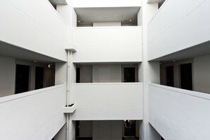 A multi-level interior with white walls and a central staircase.