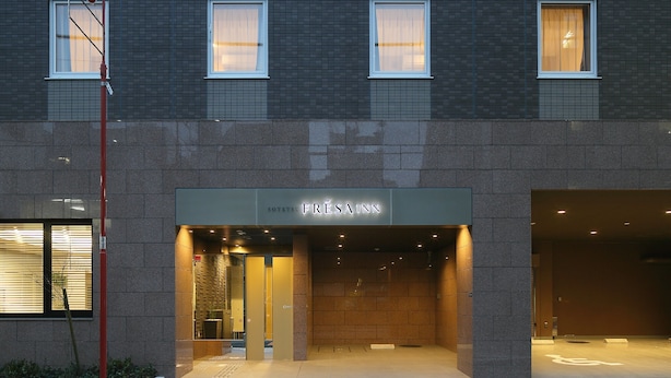 Un edificio moderno con un letrero que dice “FRESSAINN” y una entrada visible.