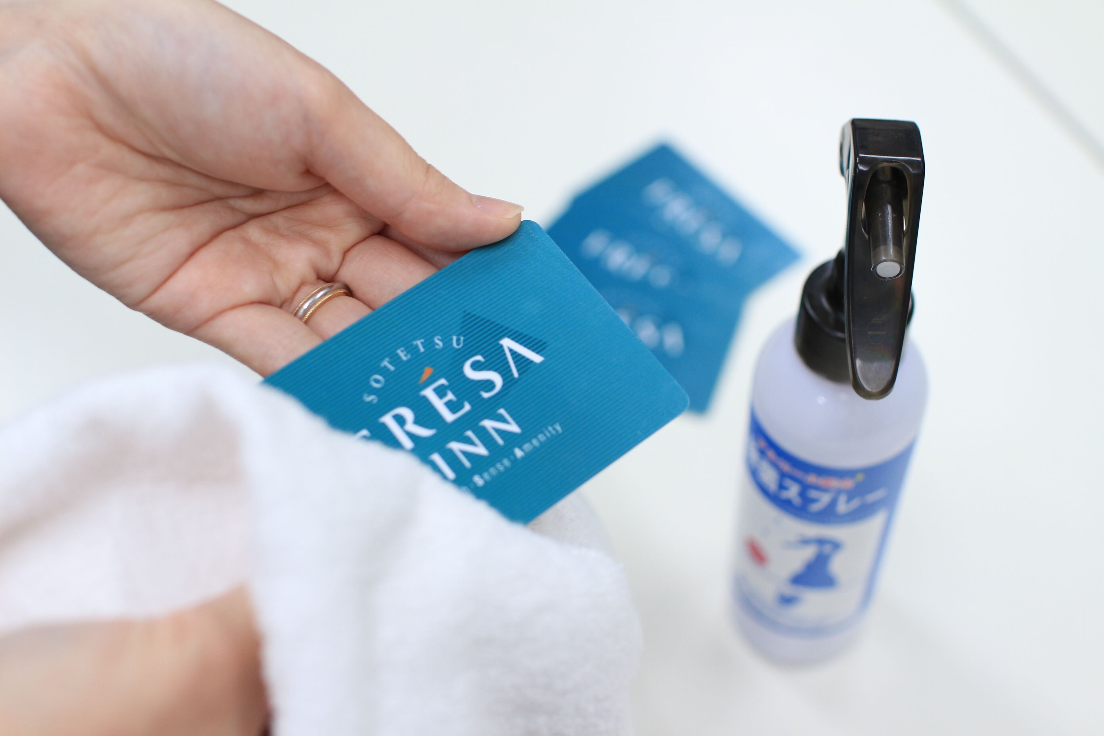 Una mano sosteniendo una tarjeta azul con el texto 'RESINA' y una botella con dispensador.