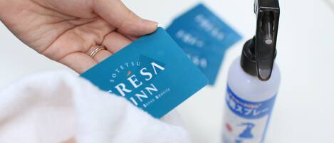 Una mano sosteniendo una tarjeta azul con el texto 'RESINA' y una botella con dispensador.