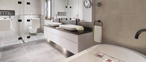 A modern bathroom with a large bathtub, two sinks, a glass shower enclosure, and a large mirror.