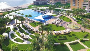 Un complexe hôtelier doté d’une grande piscine, de plusieurs espaces de détente et offrant une vue sur l’eau.