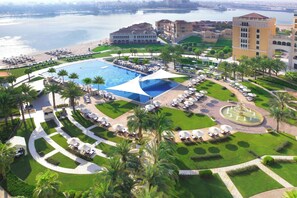 Un complexe hôtelier doté d’une grande piscine, de plusieurs espaces de détente et offrant une vue sur l’eau.