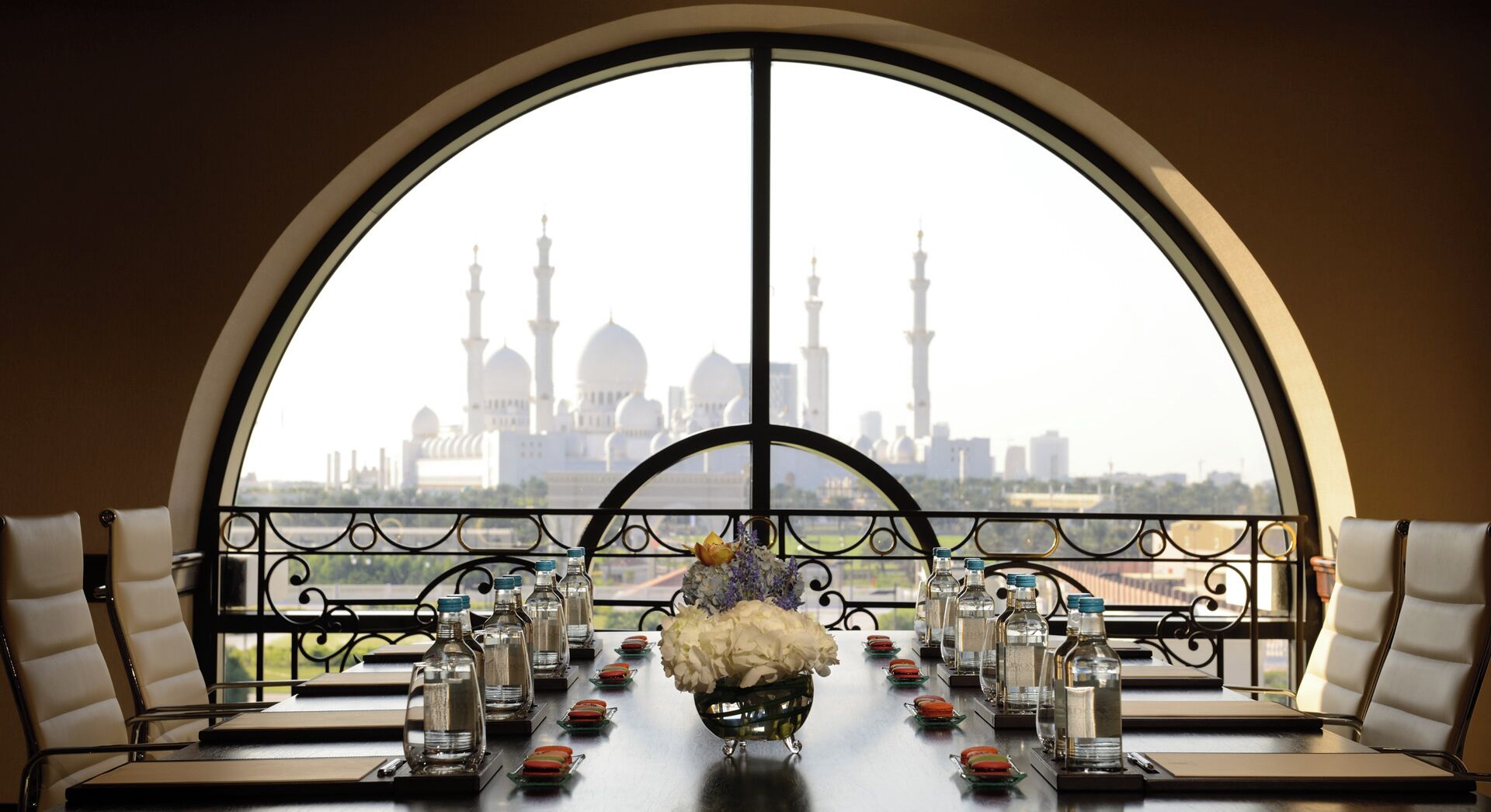 Une table dressée pour le dîner, avec vue sur les minarets d’une mosquée.