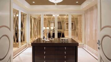 A luxurious room with a dark wooden dresser, a chandelier, and mirrored walls.