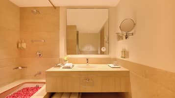 A modern bathroom with a bathtub, a sink, a mirror, and a shower.