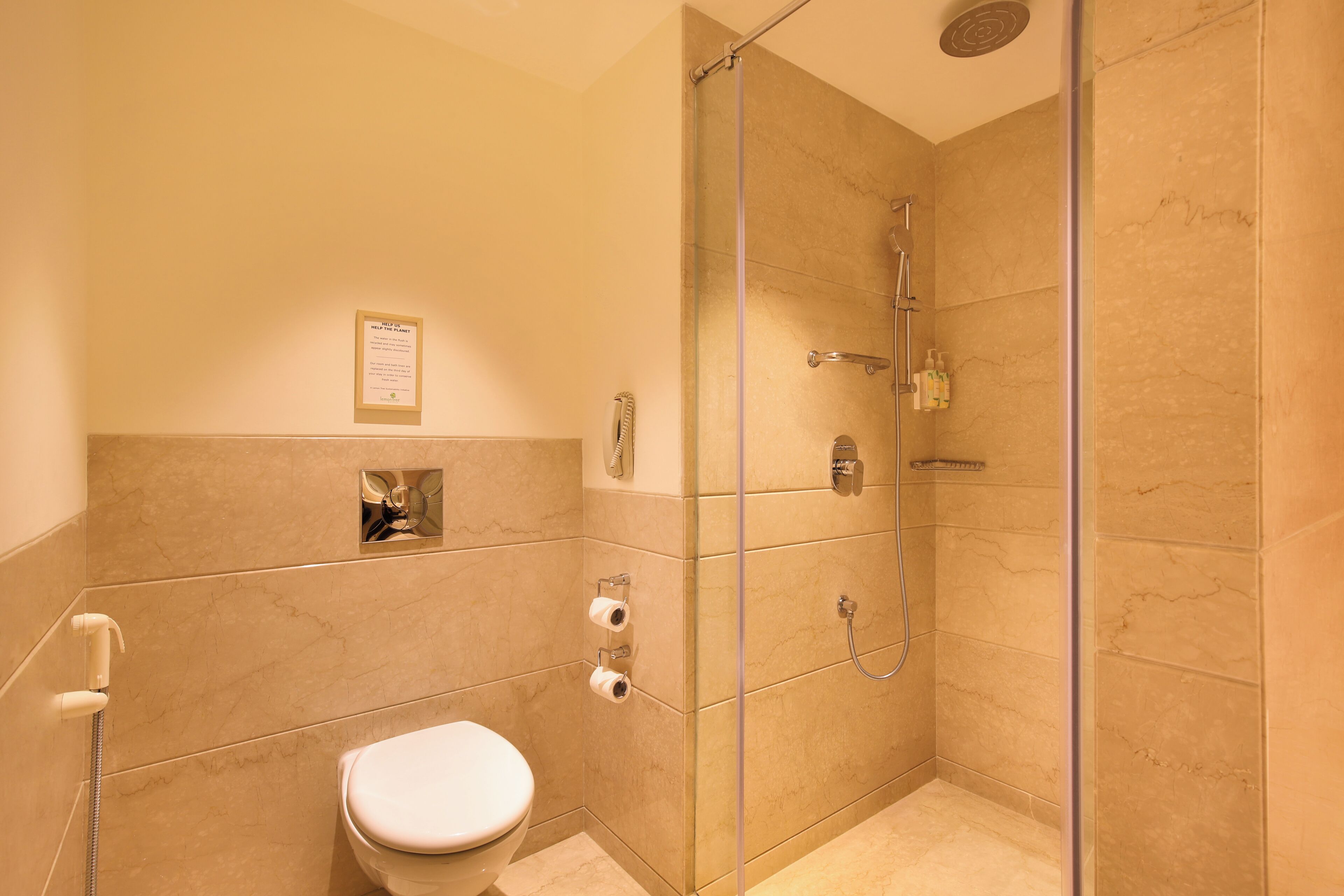 A bathroom with a toilet, a shower, and a glass-enclosed shower stall.