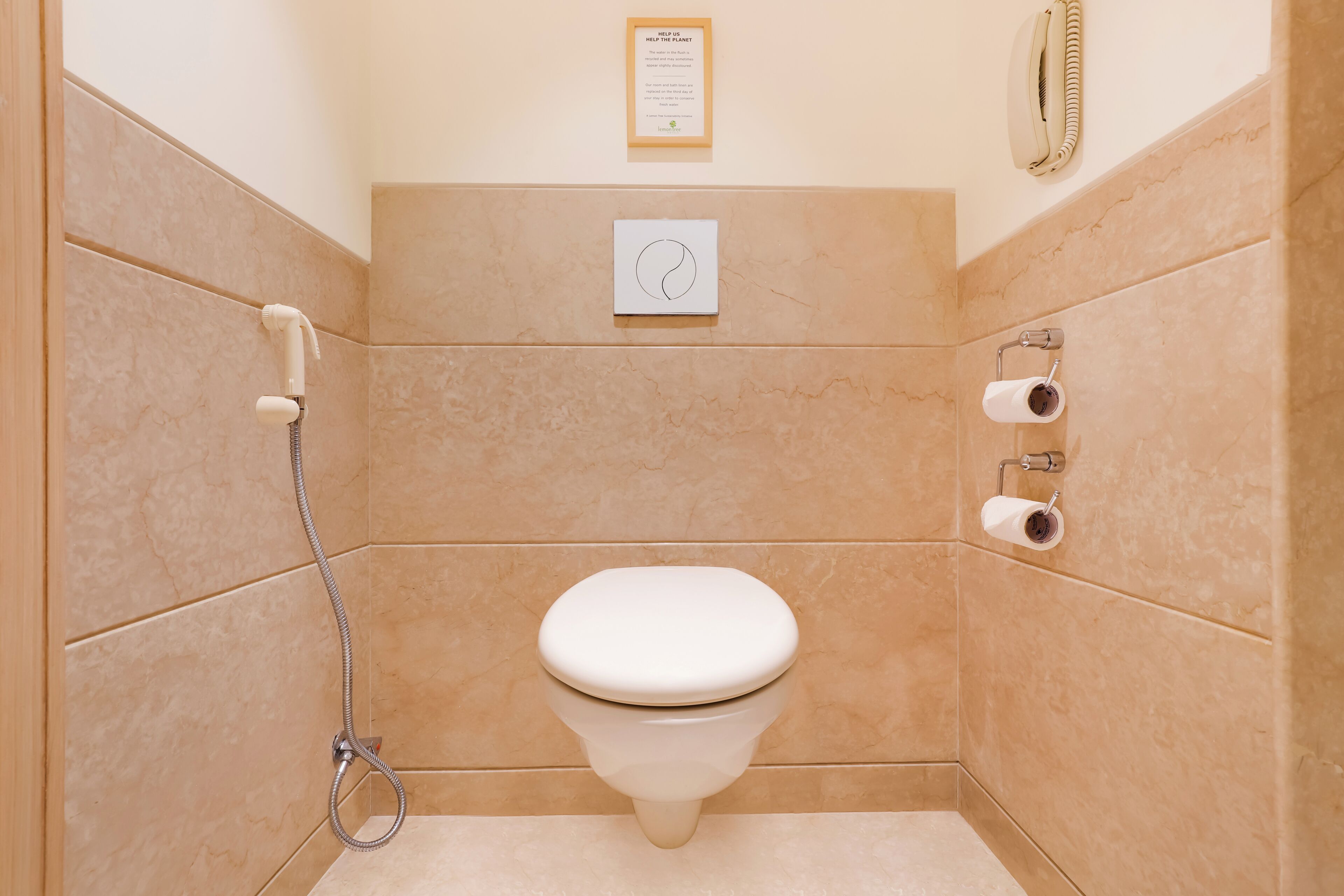 A small bathroom with a toilet, a shower, and a toilet paper holder.