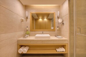 A modern bathroom with a large mirror, a sink, and a shower area.