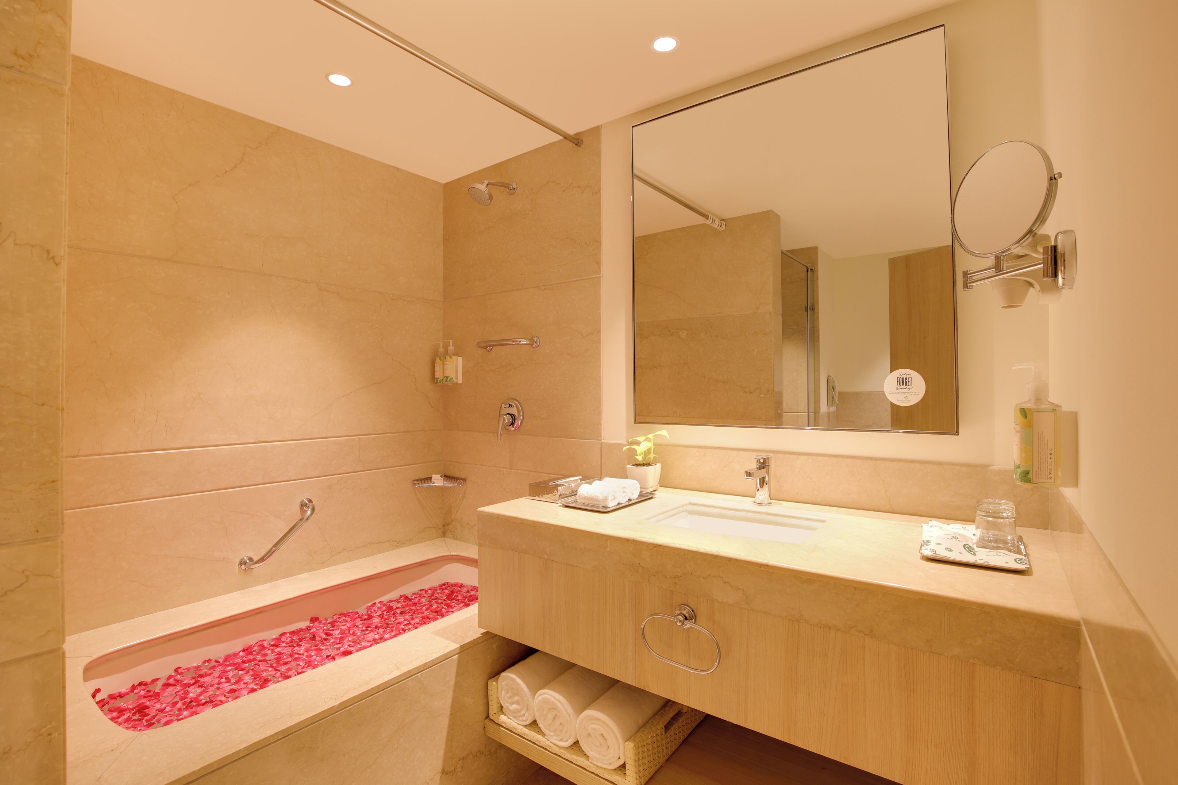Een moderne badkamer met een badkuip, wastafel, spiegel en douche.