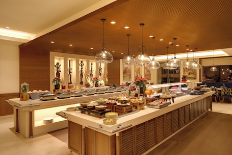 Un buffet con diversi cibi, un soffitto in legno e lampade a sospensione.. Lemon Tree Premier, Delhi Airport