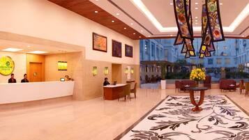 Welcome to our hotel lobby, where friendly staff are always available to assist you. The lobby features a stunning chandelier, beautiful artwork, and a comfortable seating area.