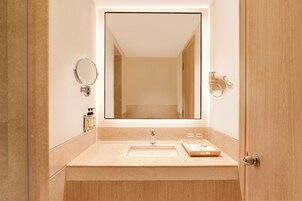 Een badkamer met een wastafel, spiegel en handdoekhouder.