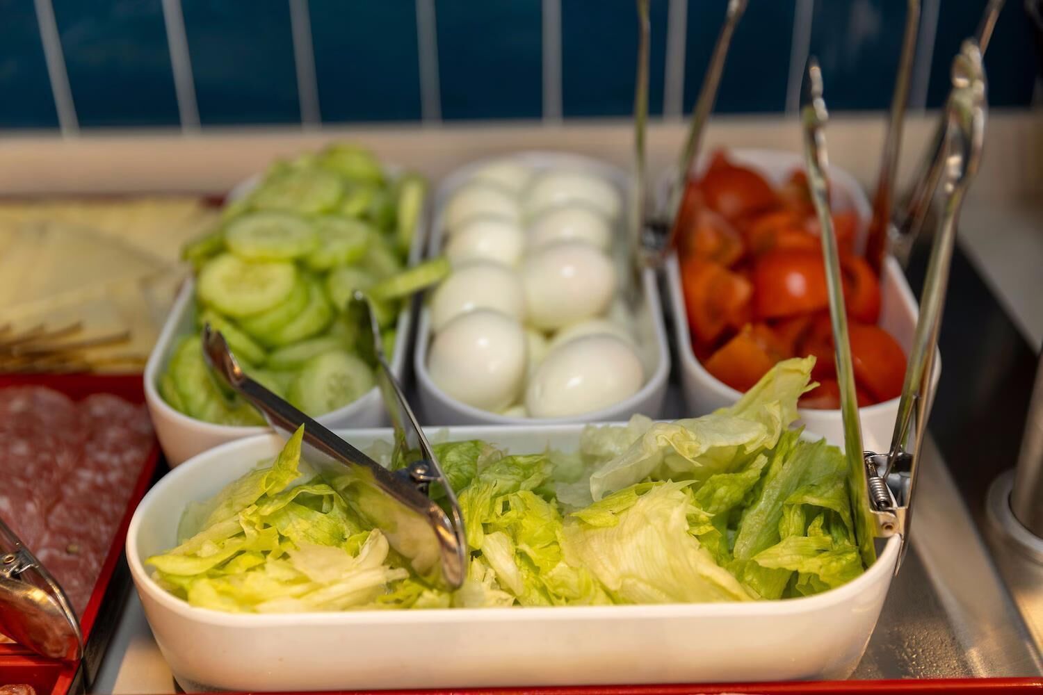 A salad bar with various vegetables and eggs.