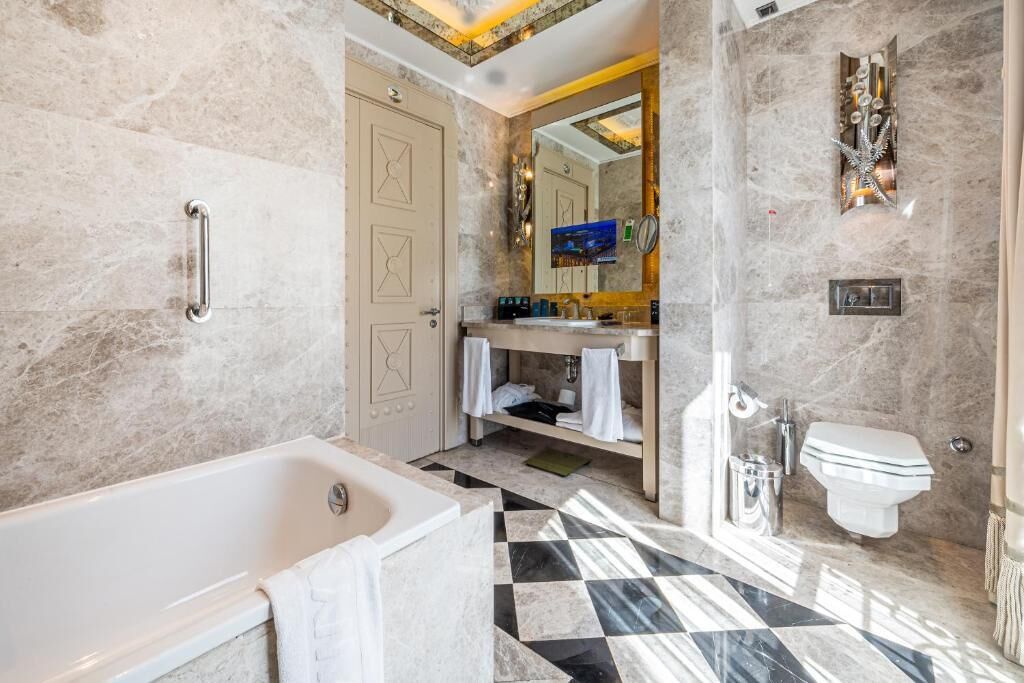 Une salle de bain moderne équipée d’une baignoire, de toilettes et d’un espace douche.