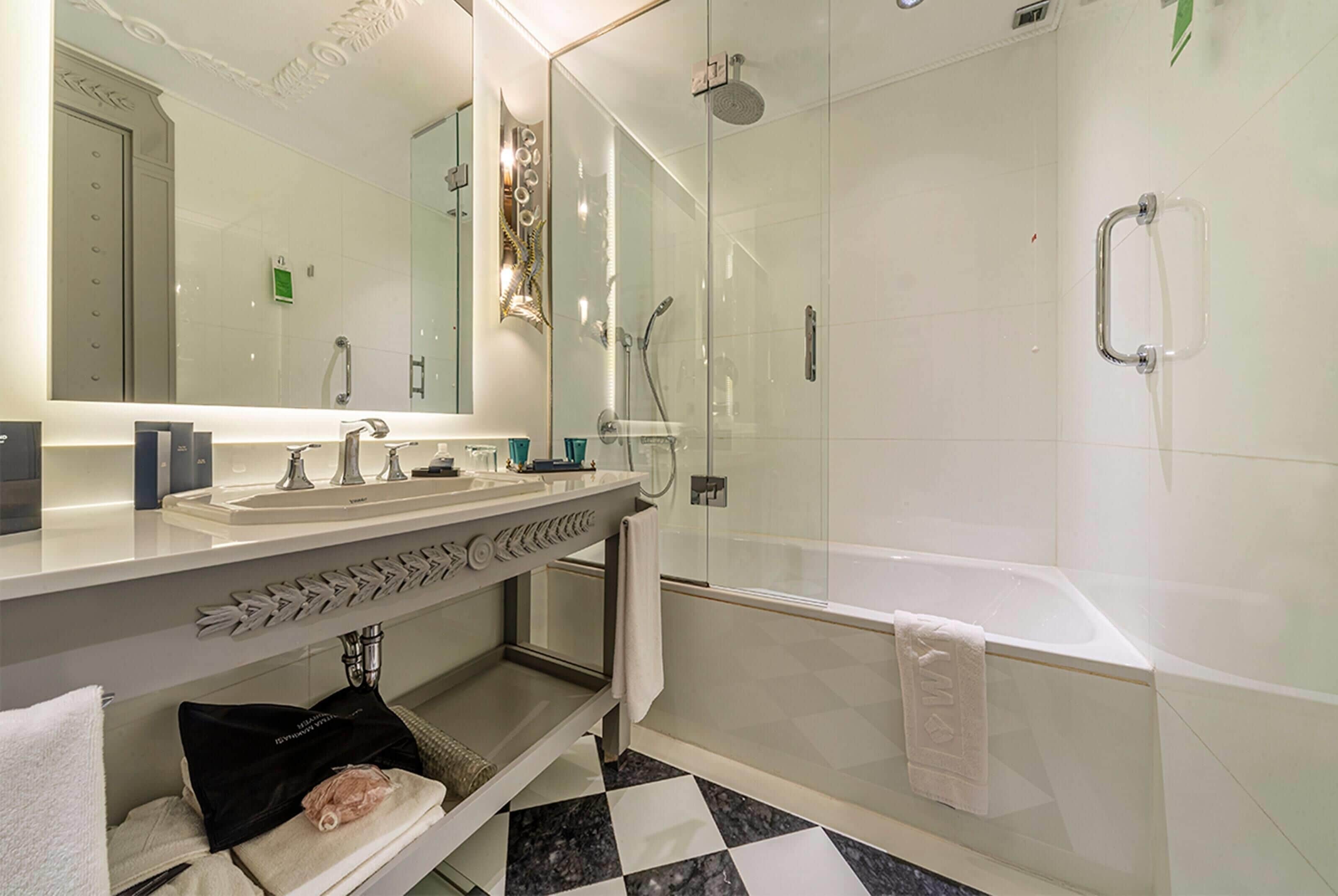 A modern bathroom with a glass-enclosed shower, a double sink vanity, and a large mirror.