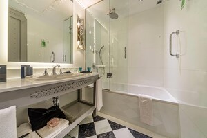 A modern bathroom with a glass-enclosed shower, a double sink vanity, and a large mirror.