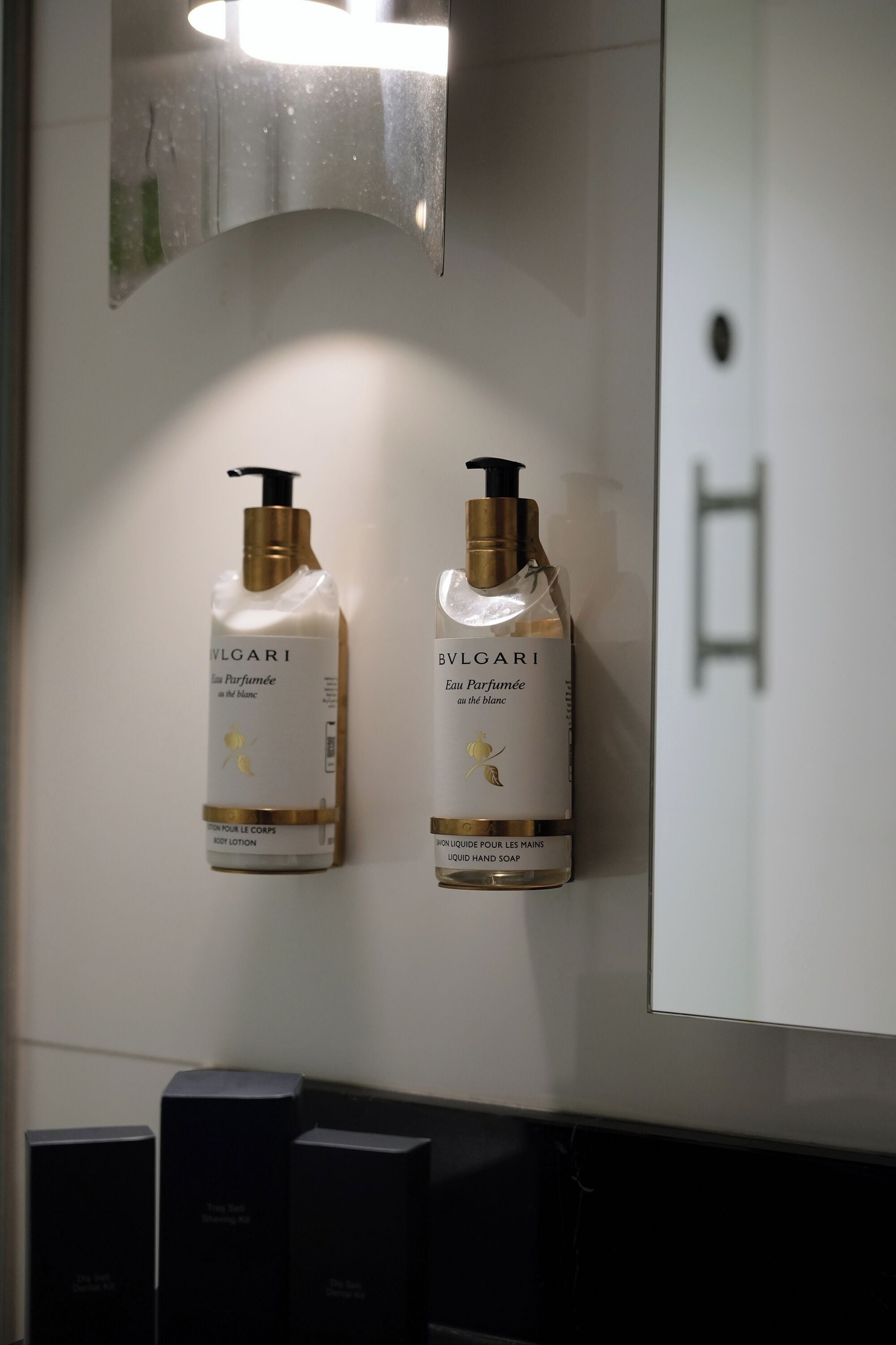 Dos botellas de perfume Bulgari sobre una pared.