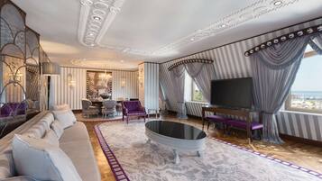 Een luxueuze woonkamer met een grote bank, een salontafel met glazen blad en een televisie.