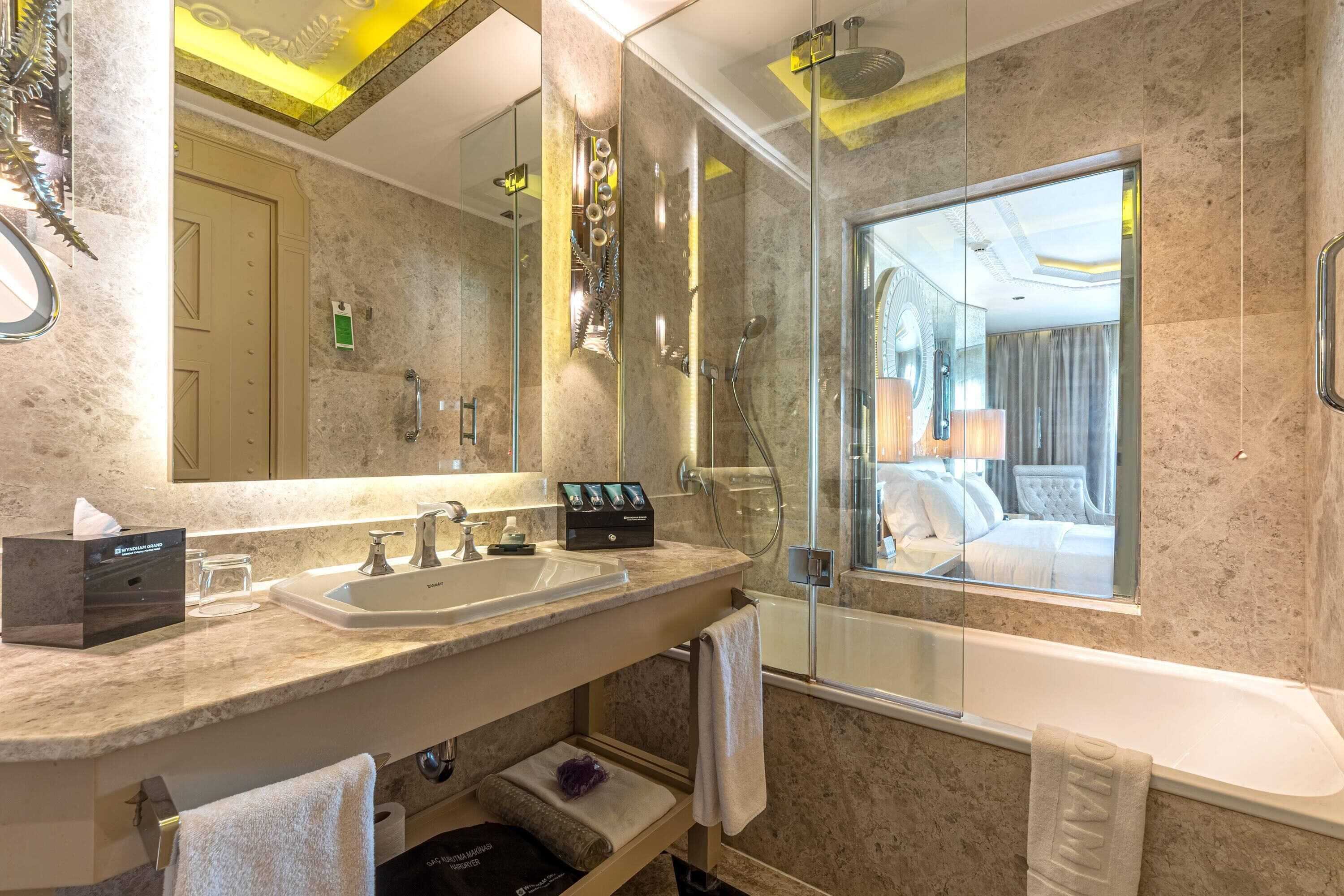 Ein modernes Badezimmer mit einem Doppelwaschbecken, einem großen Spiegel, einer Dusche mit Glastrennwand und einer Badewanne.
