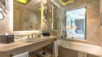 Ein modernes Badezimmer mit einem Doppelwaschbecken, einem großen Spiegel, einer Dusche mit Glastrennwand und einer Badewanne.