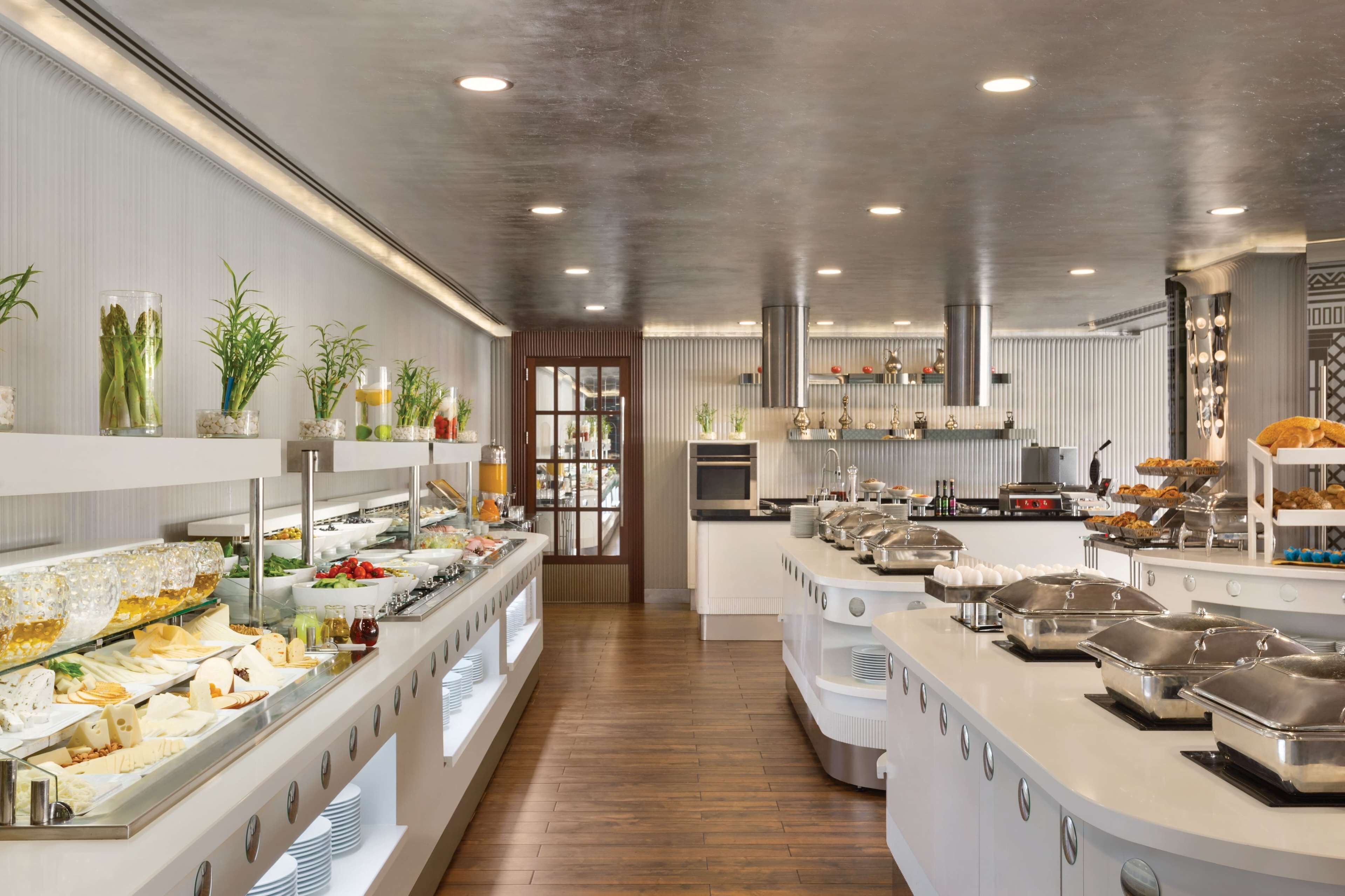 A buffet setup with various food items and a modern kitchen in the background.