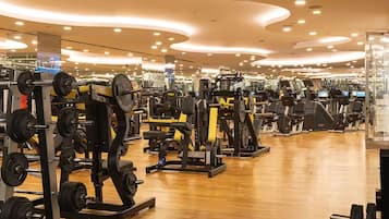 Un gimnasio moderno con diversos equipos de ejercicio, como máquinas de pesas y cintas de correr.