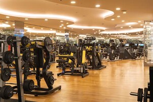 Un gimnasio moderno con diversos equipos de ejercicio, como máquinas de pesas y cintas de correr.