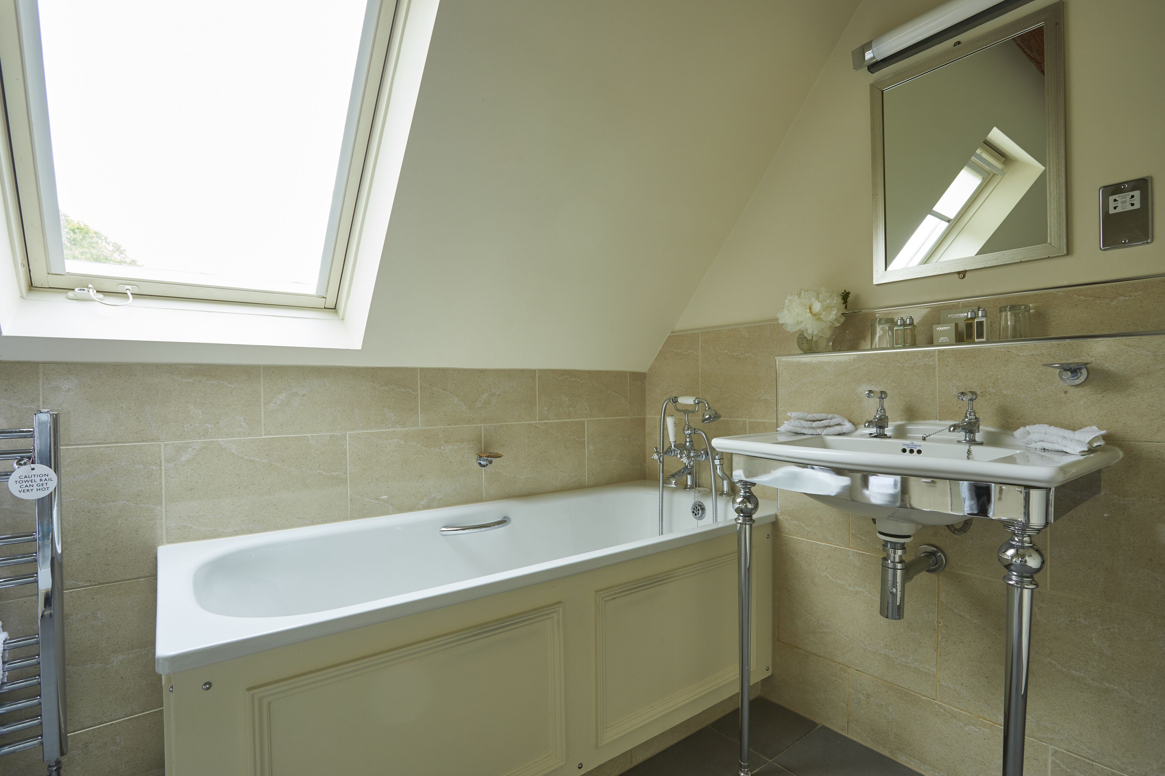 A modern bathroom with a freestanding bathtub, dual sinks, and a large mirror.