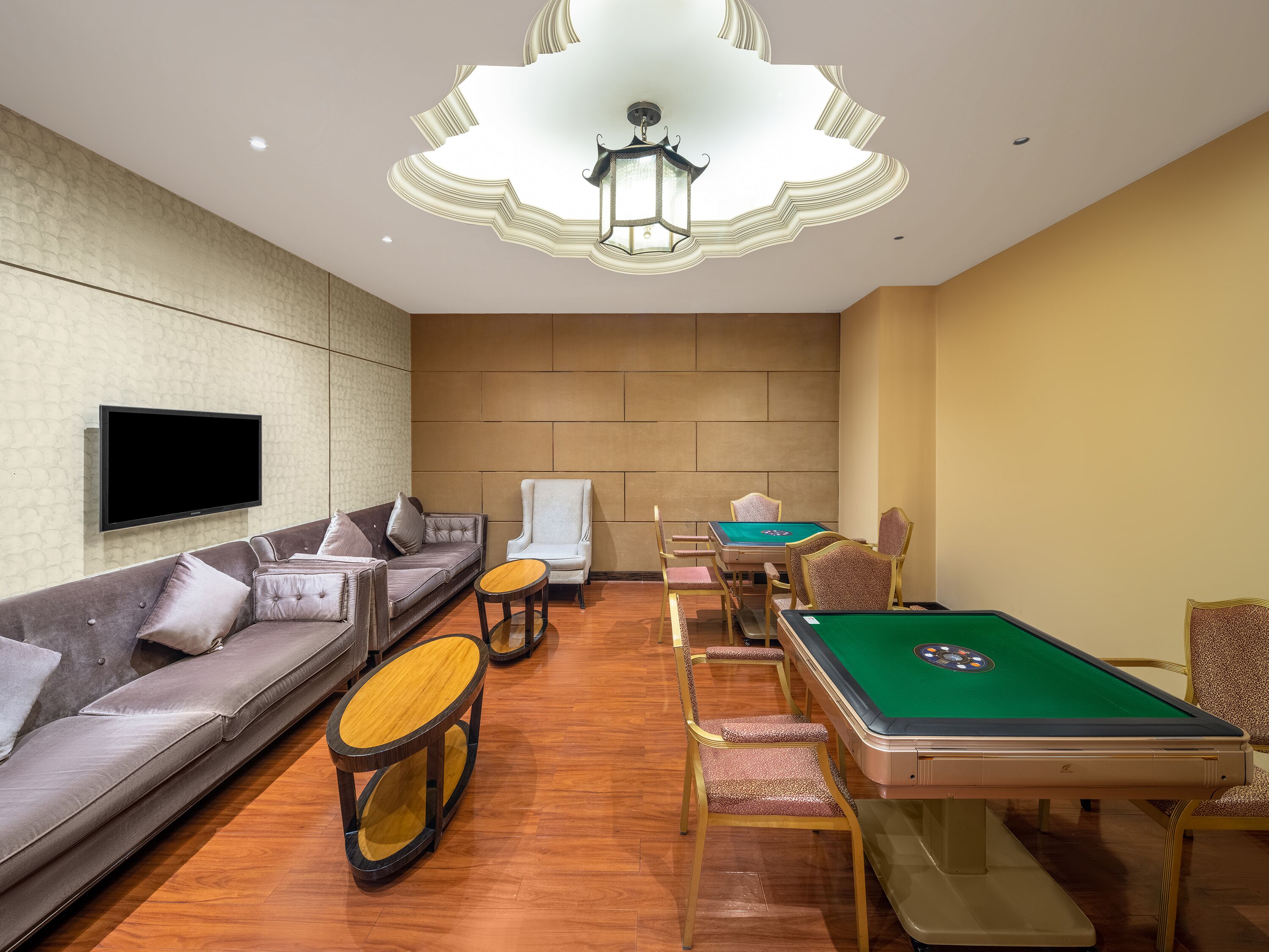 Un salón moderno con mesa de billar, asientos cómodos y un televisor de pantalla plana.