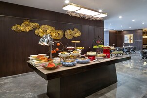 A buffet setup with various dishes and a decorative wall.