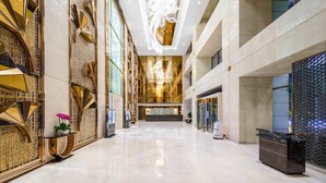 Un vestíbulo amplio y moderno con techo alto y una zona de recepción central.