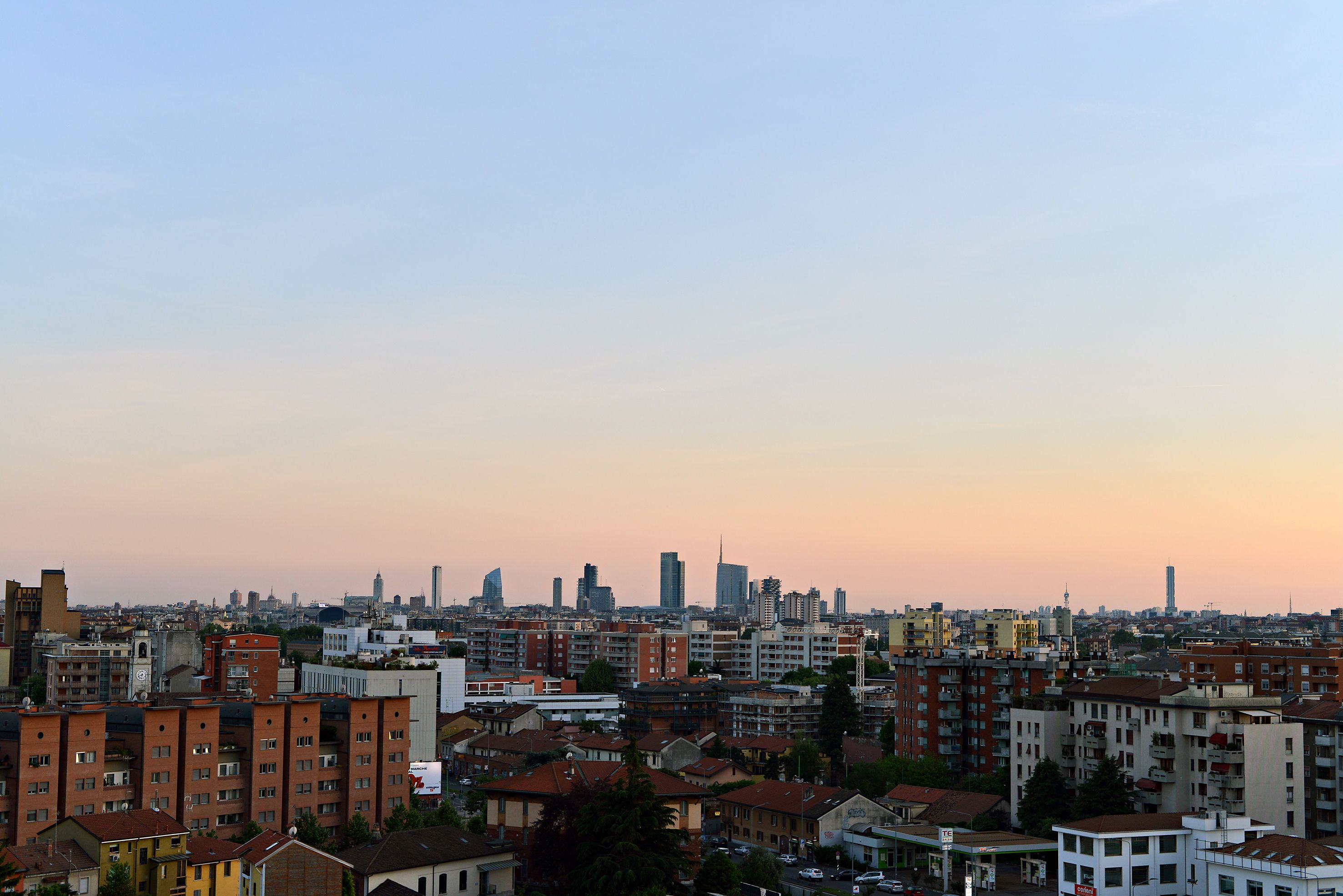 A cityscape with a variety of buildings, including high-rise and low-rise structures, under a clear sky.