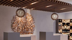 A reception area with wooden block wall art, two pendant lights, and a display of plush toys.