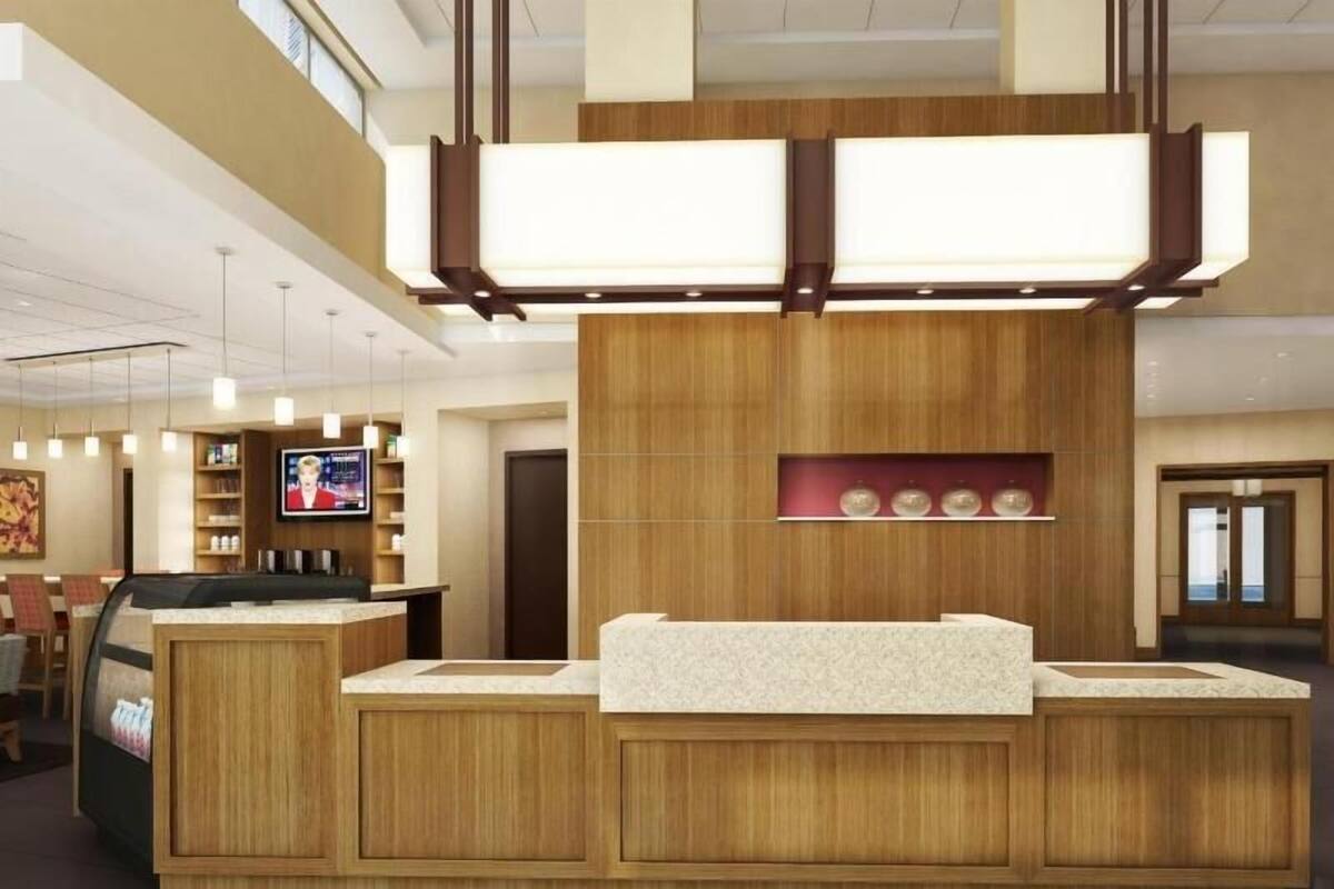 Una recepción con detalles de madera, una pantalla de televisión y una zona de estar con sillas.