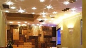 A spa room with wooden panel walls, a reception desk, and several massage chairs. - Bellaria (Predazzo)
