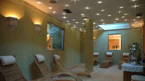 A spa room with wicker chairs, a massage table, and a ceiling with star-shaped lights. - Bellaria (Predazzo)
