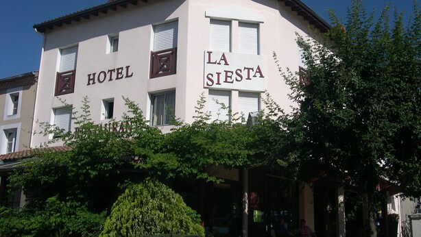 A building with 'HOTEL' and 'LA SIERRA' signage, a covered entrance, and a parked car. - La Siesta (Mont-de-Marsan)