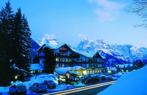 A hotel with multiple floors, snow-covered surroundings, and a mountain backdrop. - HOTEL LORENZETTI (Pinzolo)