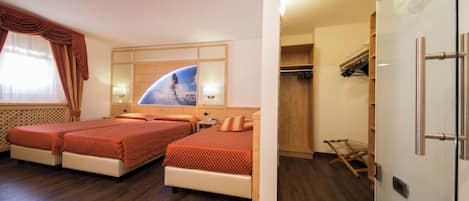 Quarto de hotel com duas camas, um guarda-roupa e um espelho com uma obra de arte ao tema espacial.