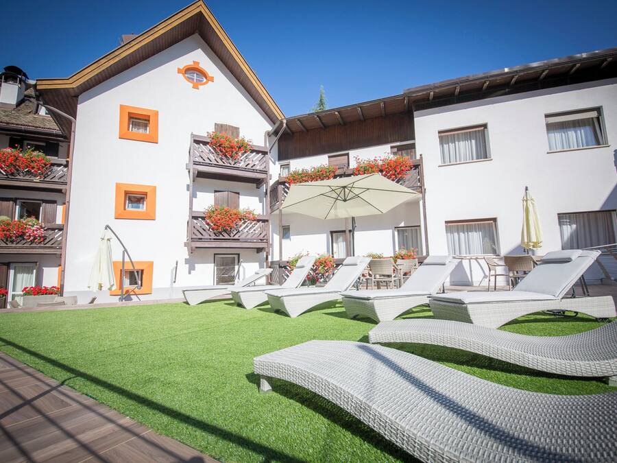 Un hôtel doté d’une terrasse sur le toit, comprenant des chaises longues et un espace salon couvert.