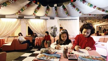 Guests can enjoy creative activities in this vibrant space with checkered floors, comfortable couches, and festive decorations.