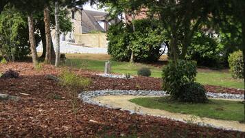 Ein angelegter Garten mit einem gewundenen Pfad, Bäumen und einem Steinschild.