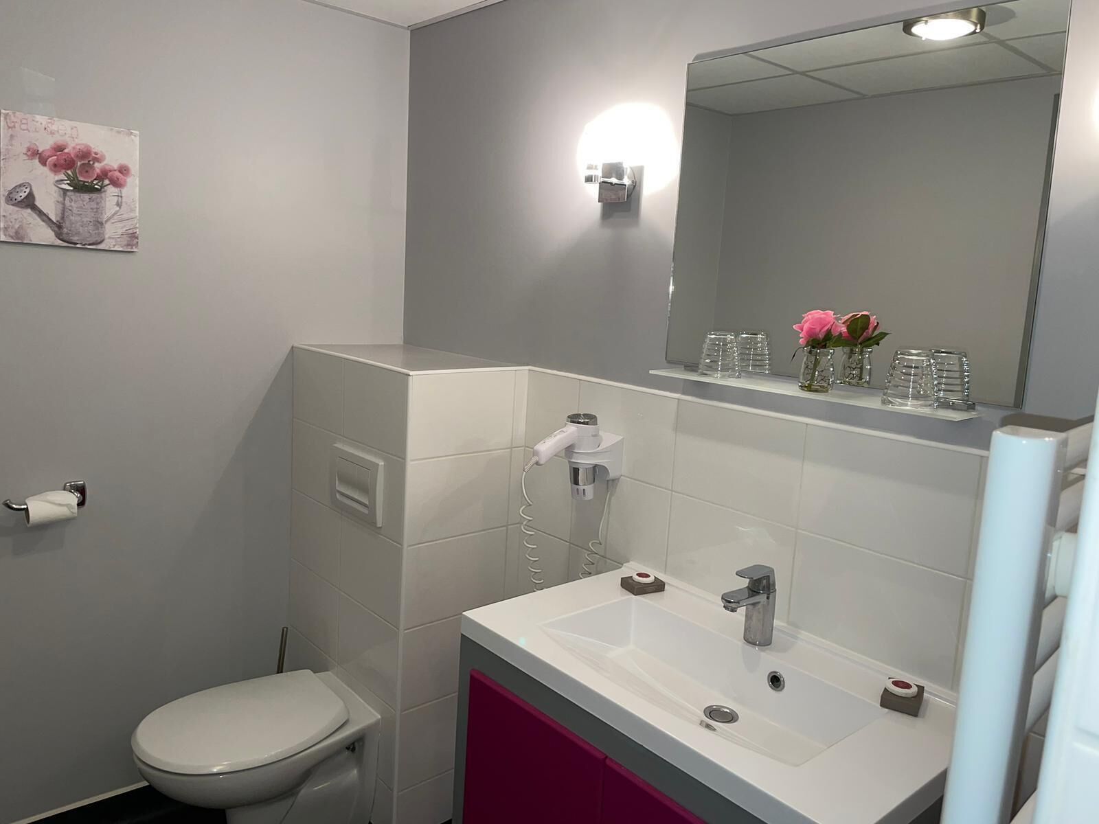 Un baño con inodoro, lavamanos y espejo.