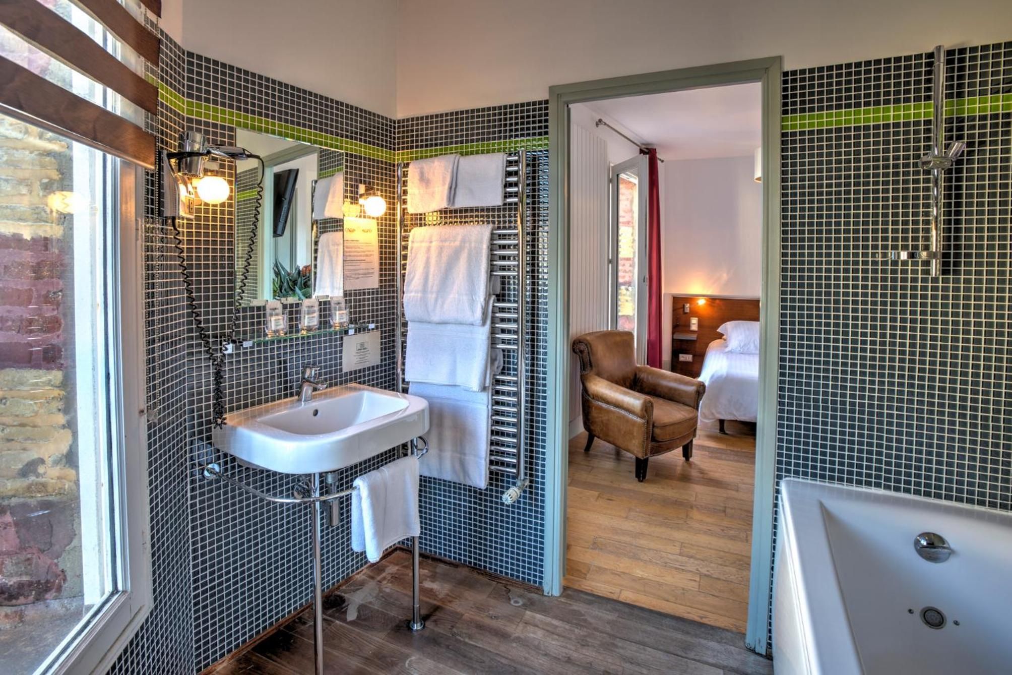 Une salle de bain avec un grand miroir, un lavabo, un porte-serviettes et un espace douche.