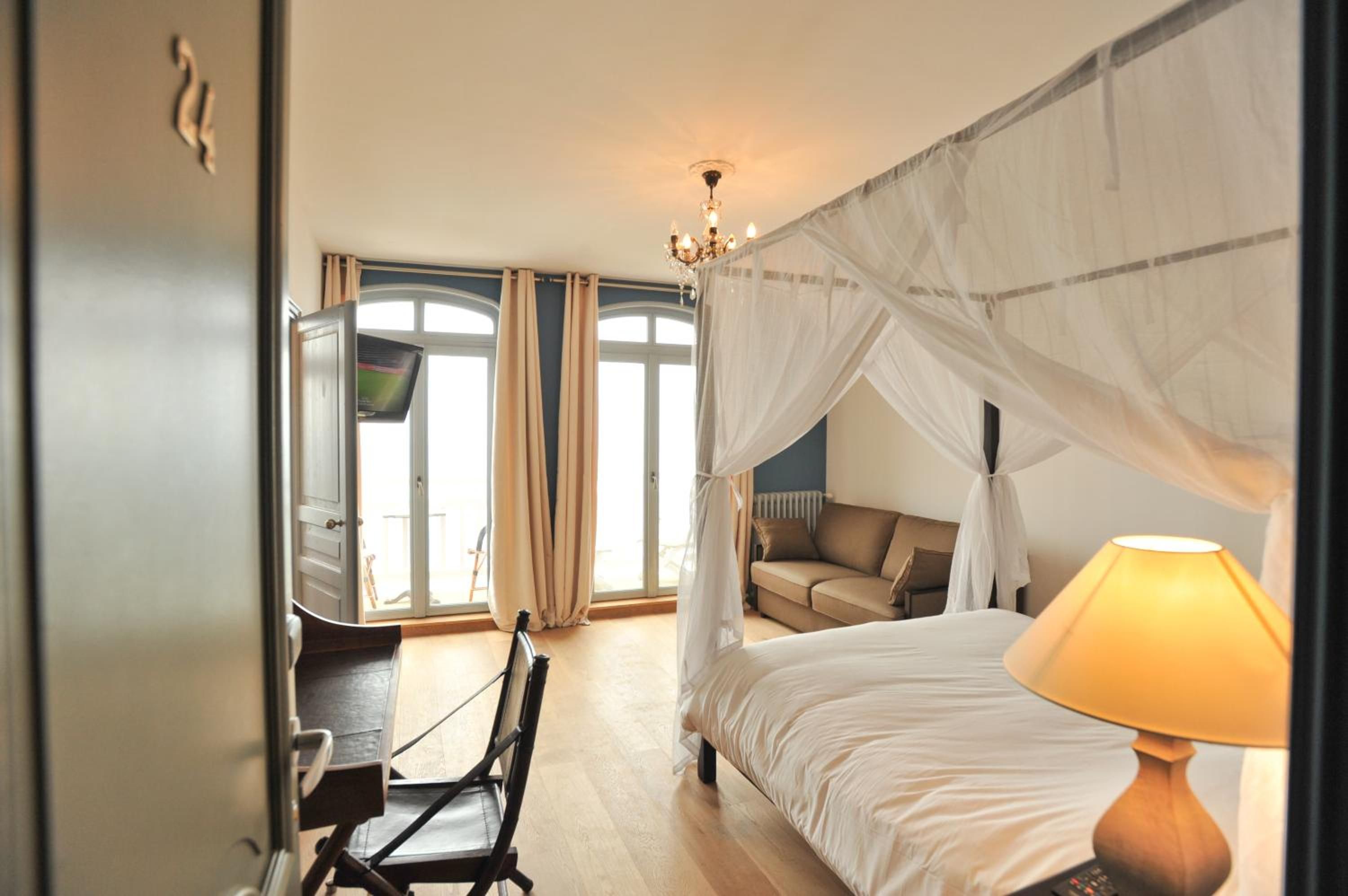 Une chambre à coucher avec un lit à baldaquin, un bureau et une chaise.