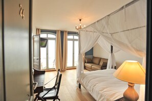 A bedroom with a four-poster bed, a desk, and a chair. - Hotel Le Rayon Vert (Etretat)