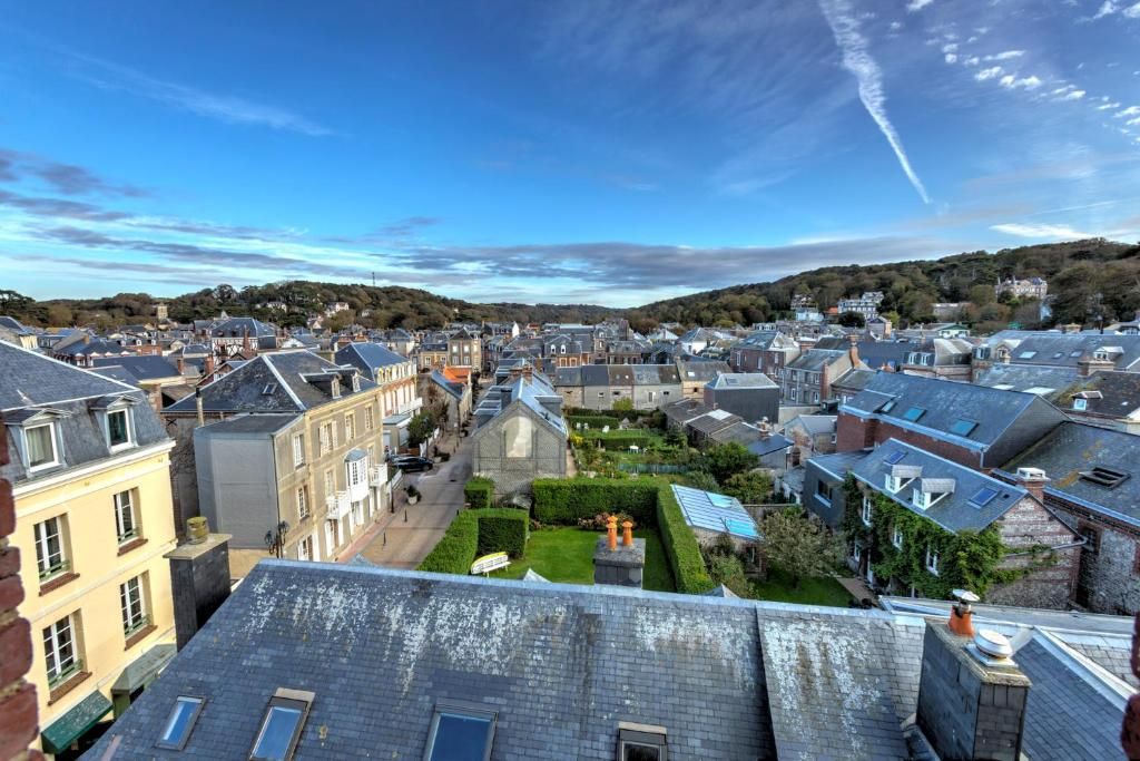 Un quartier résidentiel comprenant plusieurs maisons, une église et, au loin, une colline.