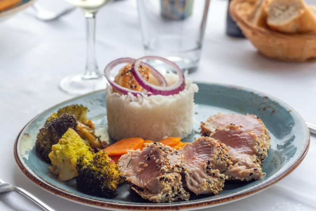 Un plato de comida con arroz, carne y verduras.