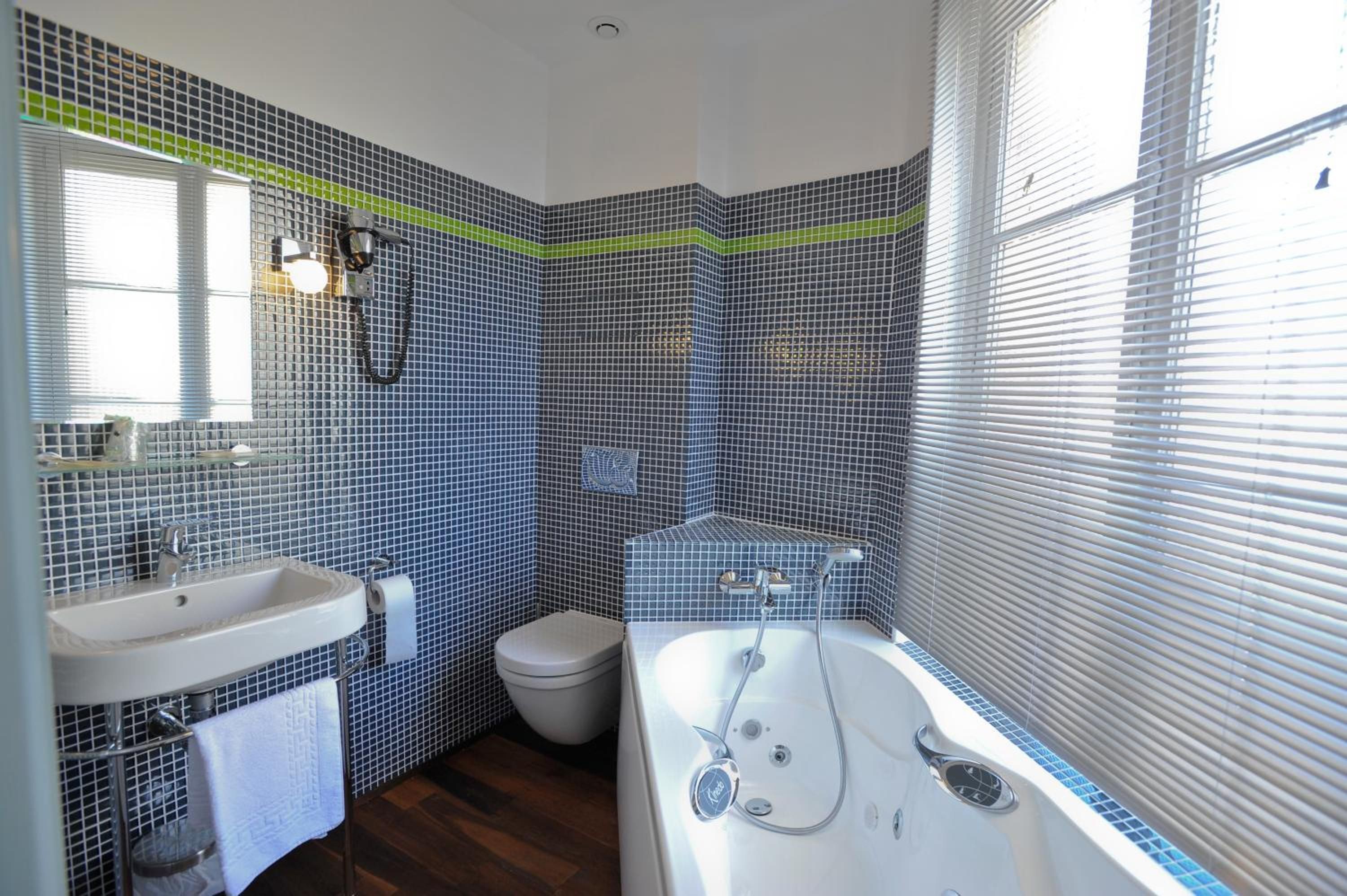 Un baño con bañera, inodoro y lavamanos.